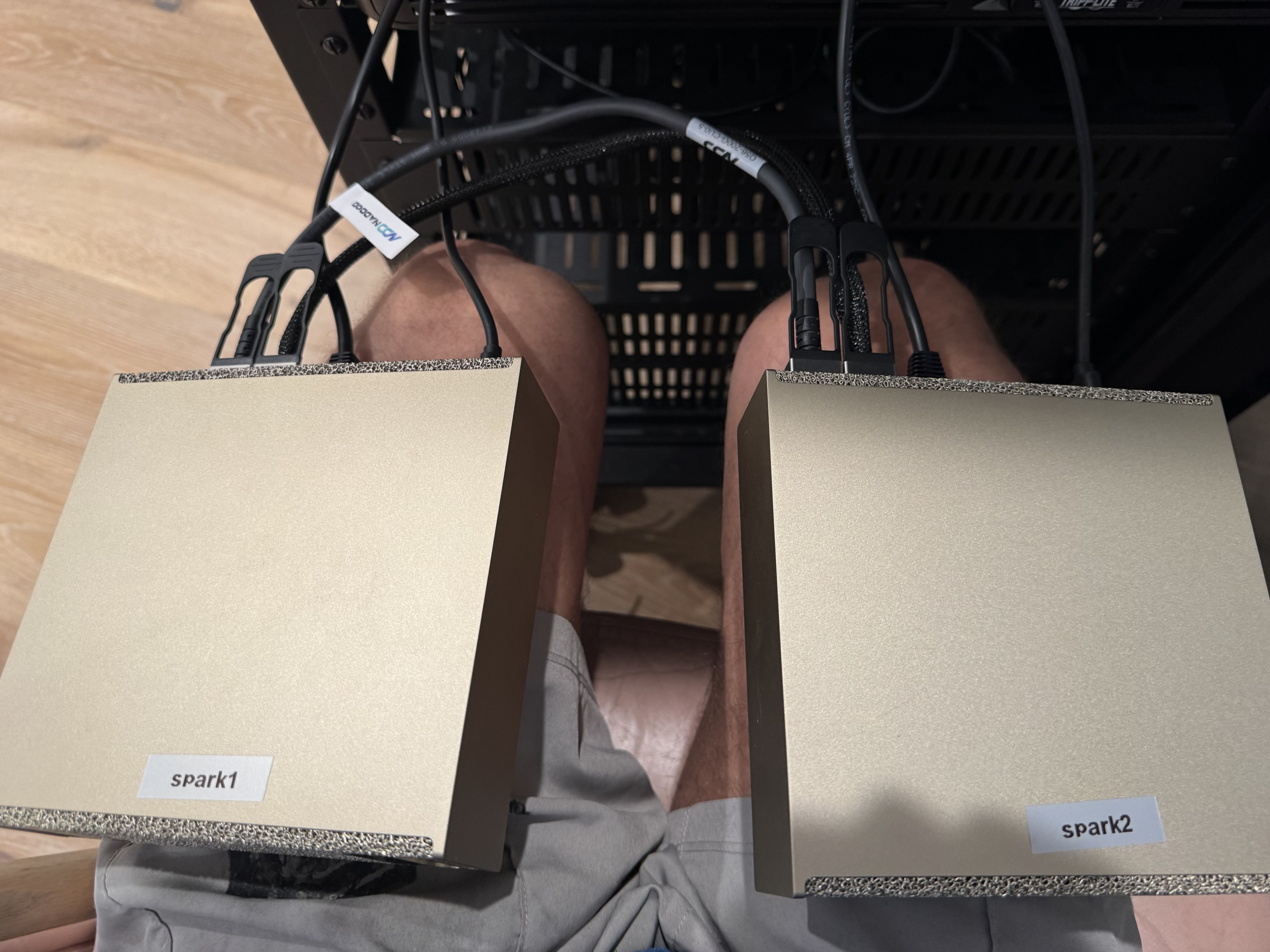 spark1 and spark2 DGX units labeled and cabled, held above the rack