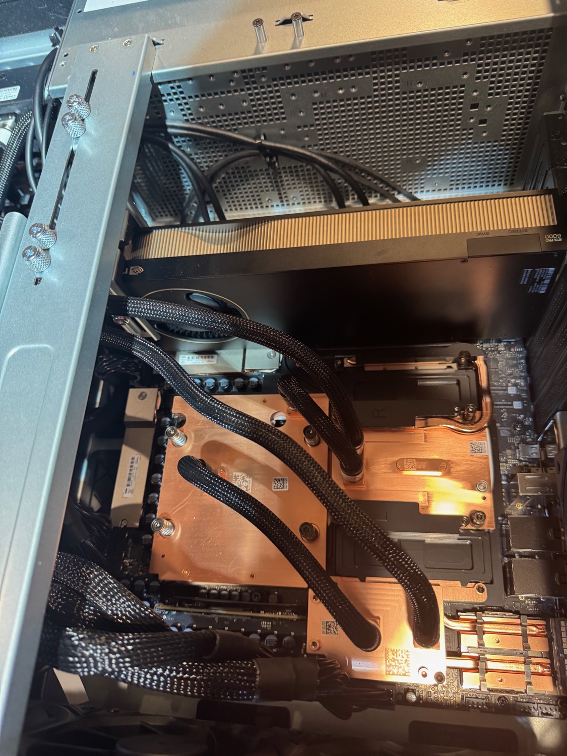 RTX PRO 6000 Blackwell Max-Q seated in the same slot, with its gold fin stack, the 16-pin cable, and the STEREO/SYNC connectors visible