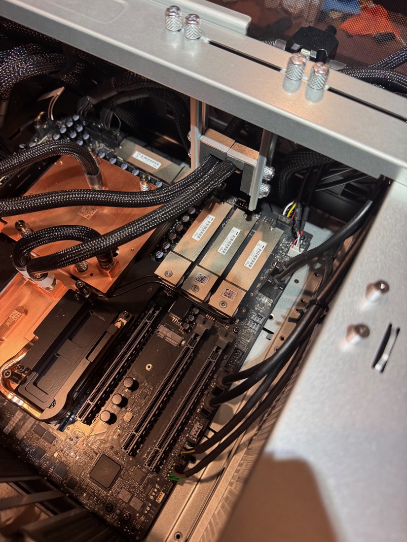 The front half of the Station's interior: Grace cold plate with braided coolant lines, three M.2 modules, and DIMM slots