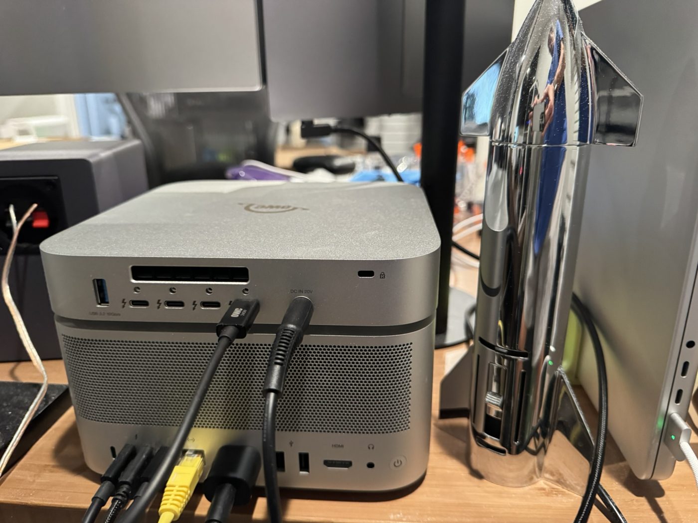 Rear of the OWC StudioStack stacked on a Mac Studio, showing the dock's Thunderbolt 5 and USB-A ports and a 20 V DC input above the Mac Studio's vent grille and ports