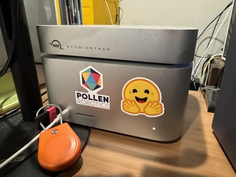 OWC StudioStack sitting on top of a Mac Studio with a Pollen Robotics sticker and a Hugging Face emoji sticker on the front